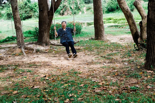 Oud volwassen ouderen Senior vrouw zittend op Swing — Stockfoto