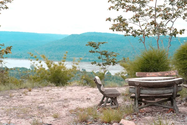 wooden bench on mountain hill with river view