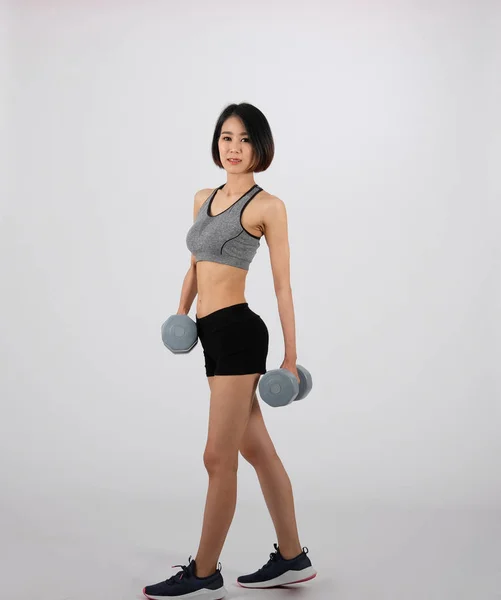 Спортивна жінка в спортивному одязі з гантелі робить фітнес тренування о — стокове фото
