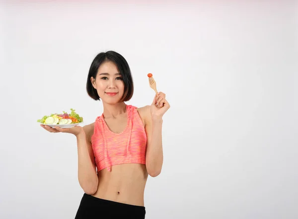 Femme de fitness sportive en vêtements de sport avec salade de légumes sur blanc — Photo