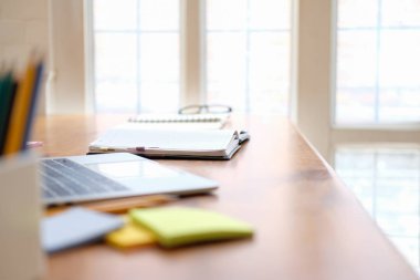 kütüphane masasında bilgisayar defteri sabit. okula geri lea