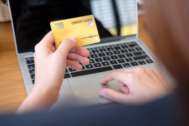 online alışveriş için bilgisayar ve kredi kartı kullanan kadın