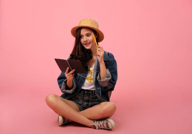 notebo ile kot ceket giyen gülümseyen asyalı kadın portresi