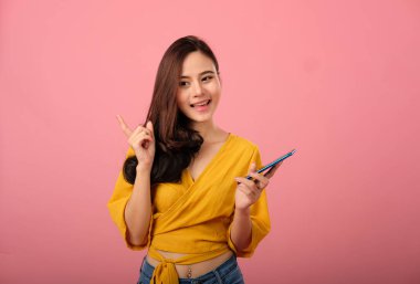 akıllı tutan rahat giyim içinde gülümseyen Asyalı kadın portresi