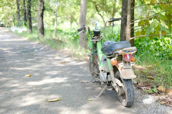 Motocicleta velha estacionada no jardim — Fotografia de Stock