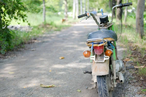 Stary motocykl motocyklowy zaparkowany w ogrodzie — Zdjęcie stockowe