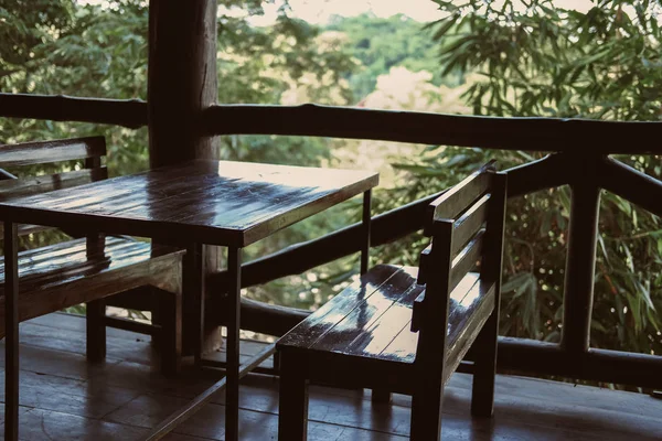 Ξύλινη καρέκλα στη βεράντα μπαλκόνι με θέα στον κήπο. — Φωτογραφία Αρχείου