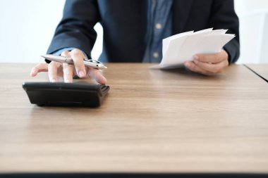 Adam iç faturaları hesaplıyor. Hesap makinesi kontrollü iş adamı