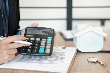 Ev modeli olan emlakçı hesaplamada fiyat numarasını gösterir