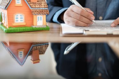 Ev modeliyle çalışan emlakçı. mortgage kredisi & satın alma r
