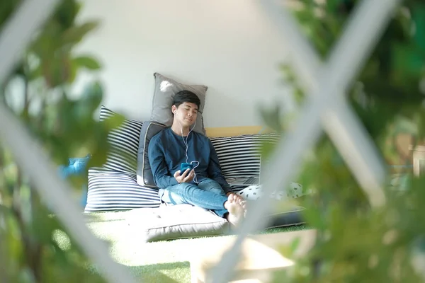 Азиатский подросток мужчина слушать музыку со смартфона Wh — стоковое фото