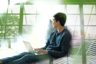 Adam evde bilgisayar kullanarak yerde oturuyor. Erkek aygır