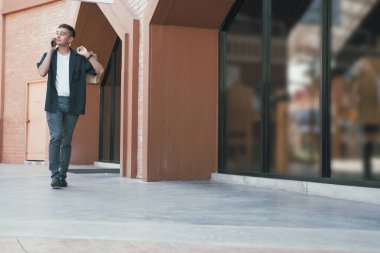 Alışveriş torbaları tutan ve cep telefonuyla konuşan adam. 