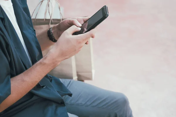 Человек с помощью мобильного смартфона с сумками . — стоковое фото