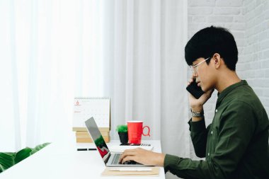 Serbest çalışan bir iş adamı cep telefonuyla konuşuyor.