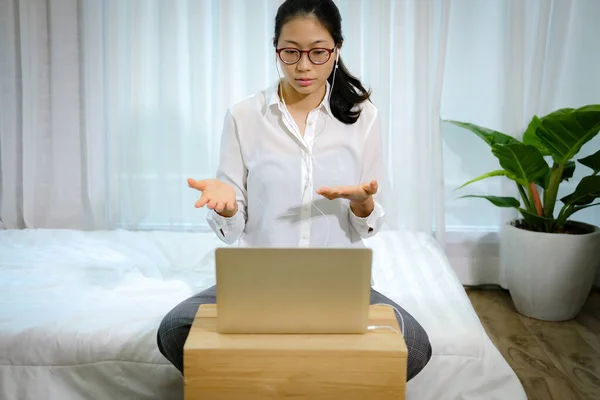 asian woman businesswoman talking with colleagues in online video conference meeting. work at home social distancing concept