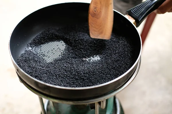 黒ゴマの種を鍋で焼く — ストック写真