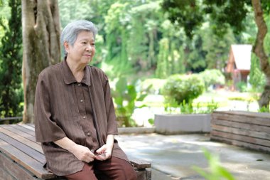 Yaşlı kadın bahçede dinleniyor. Asyalı yaşlı kadın dışarıda dinleniyor. son sınıf eğlence yaşam tarzı