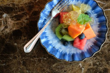 Karışık meyveli papaya kivi yabanmersinli karpuz portakalı mavi tabakta