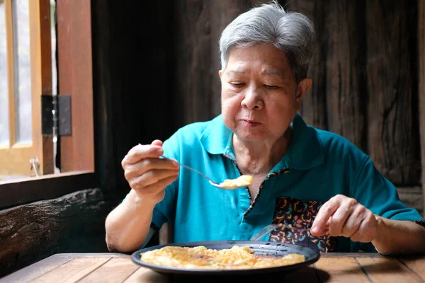 old asian elderly senior elder woman eating food at restaurant. mature retirement lifestyle
