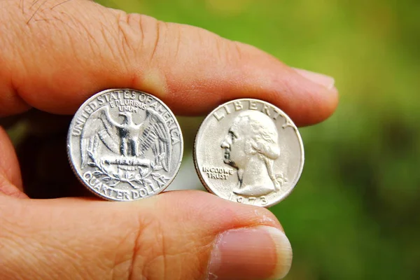 Bulanık arka plan ile elinde Amerikan sikkeleri
