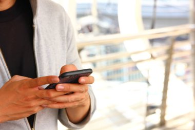 gri bez adam elinde mobil kullanıyor 