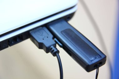 beyaz labtop yuvasında usb hattı ile siyah flash sürücü.black flash sürücü labtop için tranfer bilgi
