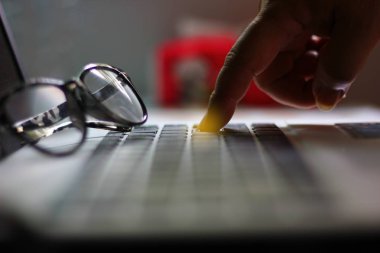 dizüstü bilgisayarın düğmesini işaret eden işçi.worker tuşuna basarak işini sil veya işini kurtarmak için butuna bas.