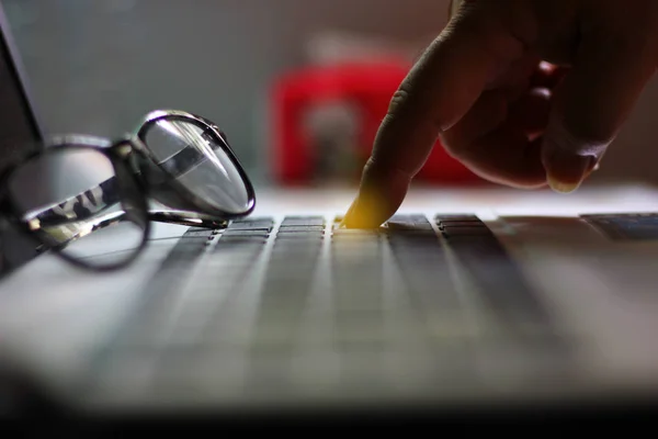 dizüstü bilgisayarın düğmesini işaret eden işçi.worker tuşuna basarak işini sil veya işini kurtarmak için butuna bas.