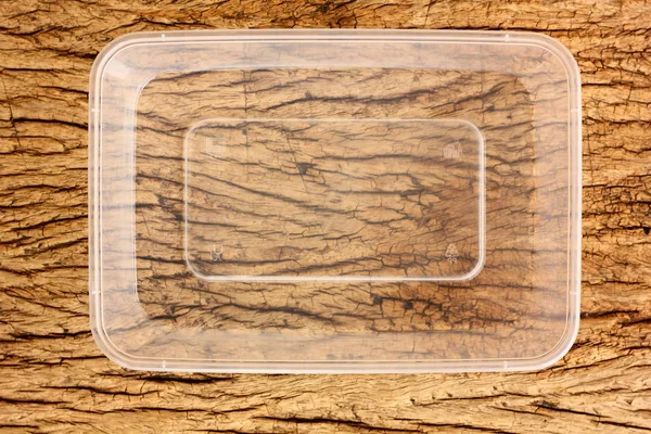 topview,flatlay empty plastic food box on retro wood floor. used plastic box can recycle to save environment and power.