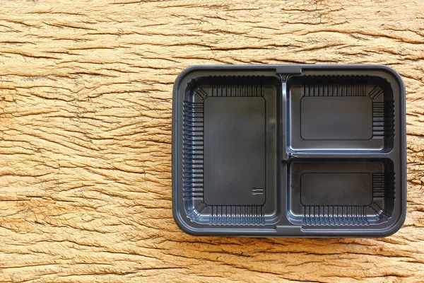 topview,flatlay empty plastic food box on retro wood floor. used plastic box can recycle to save environment and power.