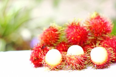 Enfes taze rambutan tropikal meyvesi ve bulanık arka planlı Rambutan kabuğu gösterisi.