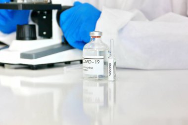 Virüs koruyucu giysisi içindeki araştırmacı, bilim adamı, doktor ya da kimyager enfekte olmuş kişilerde kullanılmadan önce son olarak mikroskop ile korona virüsü aşısını dener..