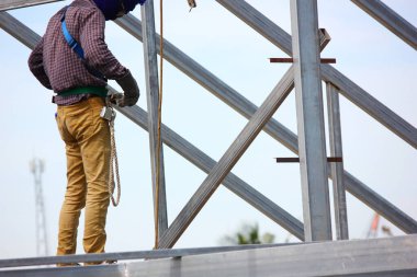 Çatı yapısında kaynak yapan işçi.