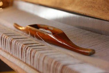 Ahşap mekiği ve beyaz iplik pamuğunu ahşap dokuma tezgahında yerel dokuma makinesinde kapat.