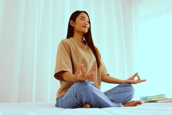 Asyalı kadın Lotus pozisyonunda meditasyon yapıyor. Nilüfer pozisyonunda meditasyon yapan kadın parmağını kapat..