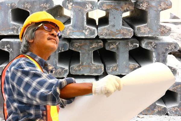 the engineer is checking product list at the factory with cement pile background