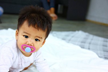 Beyaz halıda sürünen meme uçlu Asyalı bebek, kopyalama alanı