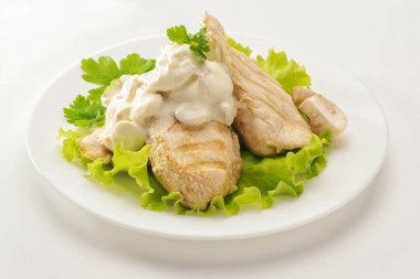 Kızarmış tavuk göğsü krema sos ve mantarlı beyaz tabakta. Beyaz arka plan