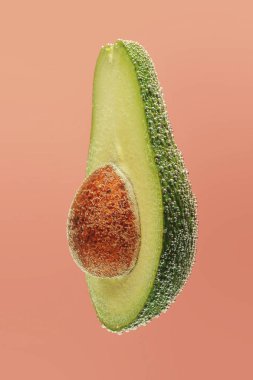 Kabarcıkları pembe bir arka plan üzerinde avokado kesmek