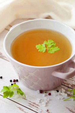 Baharat ve taze otlar ile pişmiş sıcak kemik suyu. Tıbbi diyet suyu ve süper gıda. Ketojenik diyet ve paleo diyet için. Ahşap bir arka plan üzerinde tek bir tabakta ve beyaz bir peçete ile hizmet.