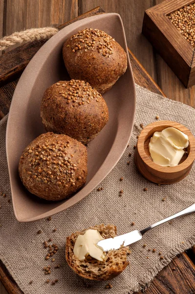 Kişniş tohumu ile pişirilen düşük karbonhidratlı glutensiz çörekler. Ahşap bir tepsi ve doğal rustik peçete üzerinde tereyağı ile servis edilir. Yukarı ve dikey görünüm. 