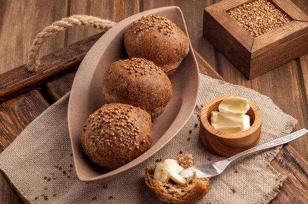 Kişniş tohumu ile pişirilen düşük karbonhidratlı glutensiz çörekler. Ahşap bir tepsi ve doğal rustik peçete üzerinde tereyağı ile servis edilir. Yukarı ve yatay görünüm. 