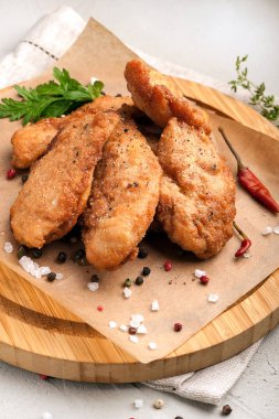 Tavuk Nuggets içinde breading. Taze sebze ve otlar ile ahşap bir tabak üzerinde hizmet vermektedir. Yakın çekim ve dikey görünüm.