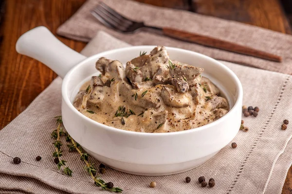 Sığır Stroganoff. Rus mutfağının geleneksel yemeği. Ekşi Krem üzerinde kalın bir sos sığır eti. Derin beyaz bir tabak üzerinde hizmet. Yakın çekim ve yatay görünüm.