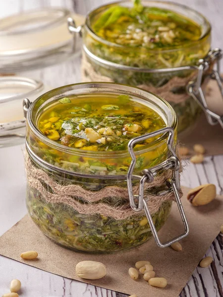 Yeşil pesto sosu. Klasik Italyan sosu. Cam bir kavanozda koruma. Rustik tarzda dekore edilmiş iki kavanoz sos. Yakın çekim ve dikey oryantasyon. 