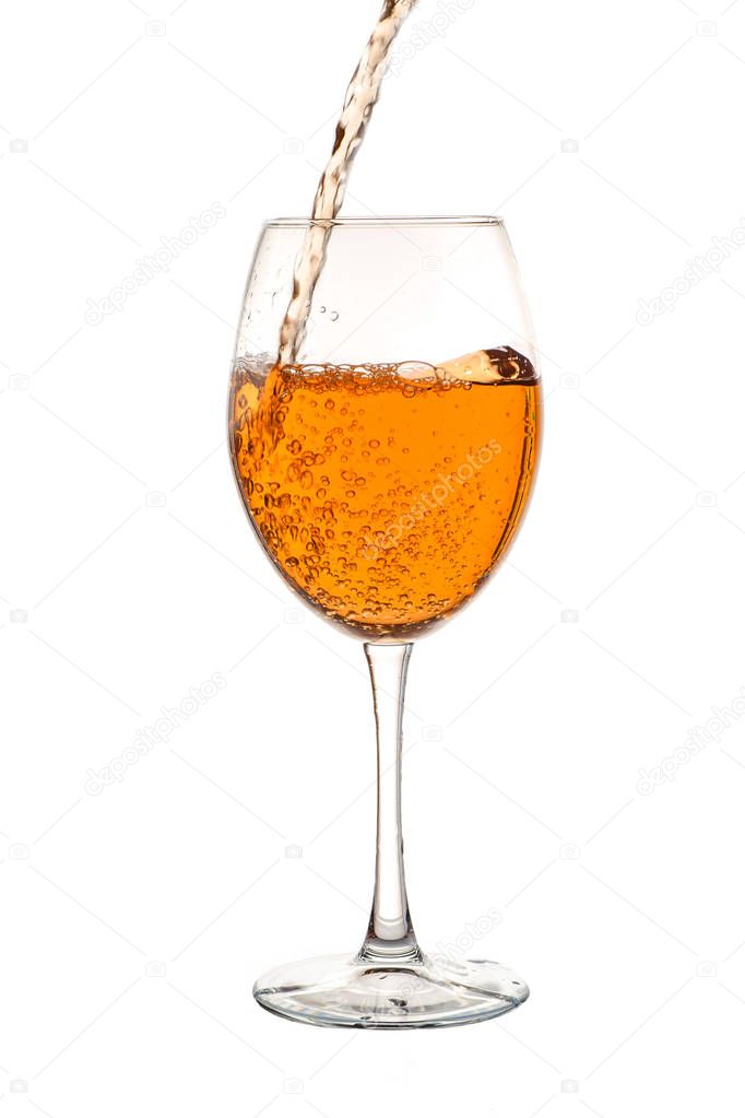 Amber wine in the glass. Wine is poured into a glass. Traditional Georgian wine according to ancient technology. Isolated on white background. Close up and vertical orientation. 
