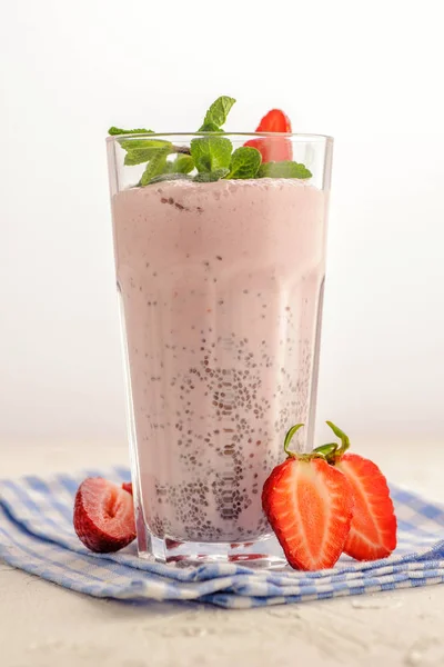 Bright pink smoothie in a tall glass.