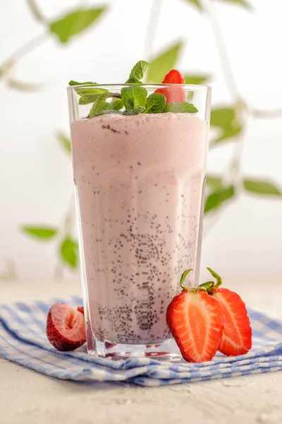 Bright pink smoothie in a tall glass.