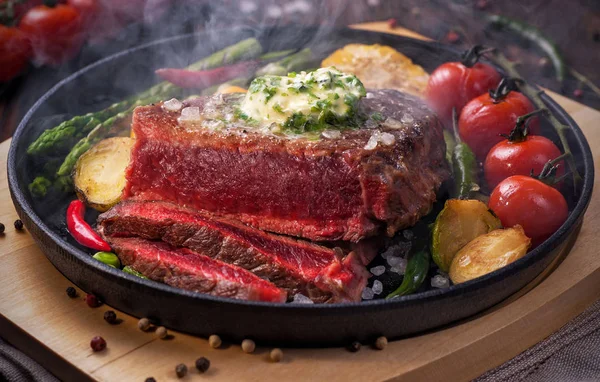 Pečené hovězí steaky středně vzácné s máslem a zeleninovou stranou — Stock fotografie